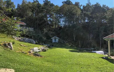 a yard with a white house in the background at Cozy Home In Førde I Hordaland in Erve