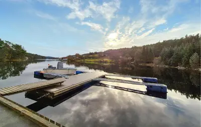 a boat is docked at a dock on a river at 1 Bedroom Cozy Home In Førde I Hordaland in Erve