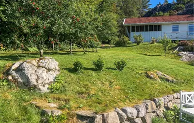 a yard with a stone wall and a house at 1 Bedroom Cozy Home In Førde I Hordaland in Erve