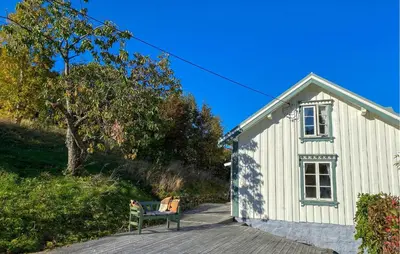 a white building with a bench in front of it at Beautiful Home In Vistdal With Wifi in Myklebostad