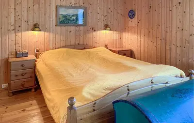 a bedroom with a bed and a wooden wall at Beautiful Home In Vistdal With Wifi in Myklebostad