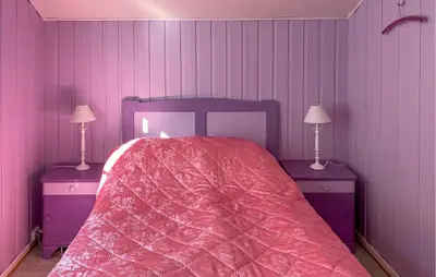 a bedroom with a bed and two tables with lamps at Beautiful Home In Vistdal With Wifi in Myklebostad