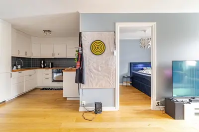 an open kitchen with white cabinets and a television at Beautiful 2-bedroom apartment in Bergen