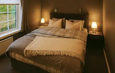 a bedroom with a large bed with two lamps at Awesome Apartment In Trysil With Sauna in Trysil