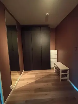 an empty room with black cabinets and a wooden floor at Cozy Studio in Hallset, Trondheim in Trondheim