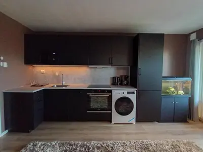 a kitchen with a washing machine and a fish tank at Cozy Studio in Hallset, Trondheim in Trondheim