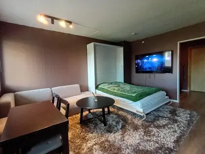 a room with a bed and a couch and a table at Cozy Studio in Hallset, Trondheim in Trondheim