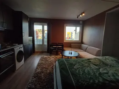 a living room with a bed and a couch and a table at Cozy Studio in Hallset, Trondheim in Trondheim