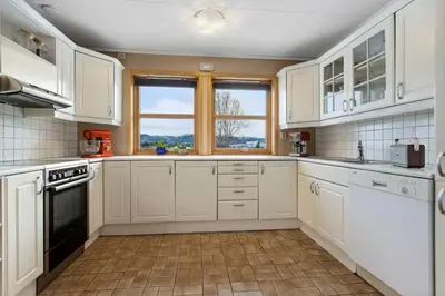 a white kitchen with white cabinets and a window at Room in Trondheim, Heimdal, Lundåsen - Bus to town every 5 minutes in Trondheim