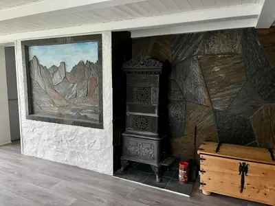 a wall with a painting and a stove in a room at Grey Lodge in Isfjorden