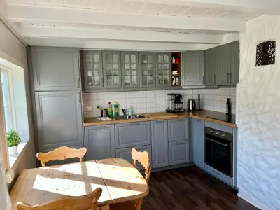a kitchen with blue cabinets and a table with chairs at Grey Lodge in Isfjorden