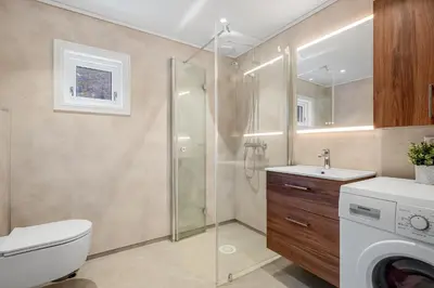 a bathroom with a toilet sink and a shower at Jordeplegarden Apartments in Tønjum