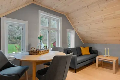 a living room with a table and a couch at Jordeplegarden Apartments in Tønjum