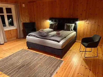 a bedroom with a bed and a chair in it at Mountain Lodge - Midtgardstunet in Ringebu