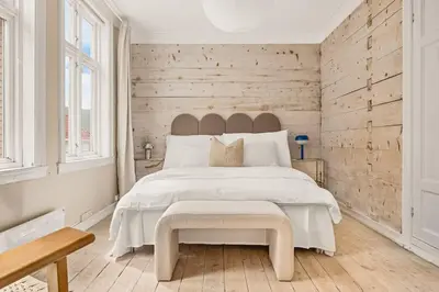 a bedroom with a large white bed and wooden walls at The 1880 Authentic Bergen Dream I 500m to Bryggen in Bergen