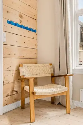 a bench in a room with a wooden wall at The 1880 Authentic Bergen Dream I 500m to Bryggen in Bergen
