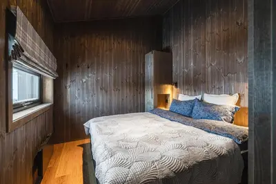 a bedroom with a bed with a wooden wall at Hemsedal ski in ski out, modern comfort by the slopes in Hemsedal
