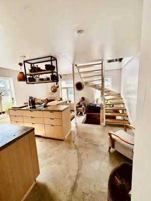 a large room with a staircase and a living room at Charming in the center of Hamar in Hamar