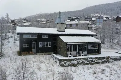 a house is covered in snow in a town at Familiehytte med fantastisk beliggenhet i Vestlia in Geilo