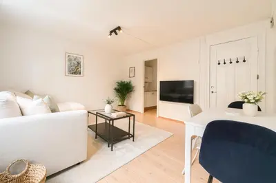 a living room with a white couch and a tv at Twin Flat 2nd Floor Bergen Centre - Norwegians minimum age 25 in Bergen