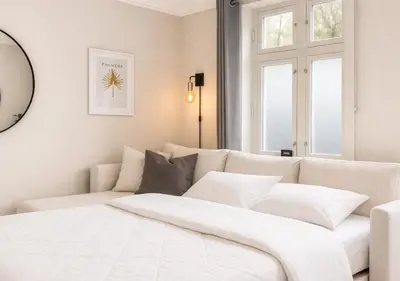 a white bedroom with a white couch and windows at Twin Flat 2nd Floor Bergen Centre - Norwegians minimum age 25 in Bergen