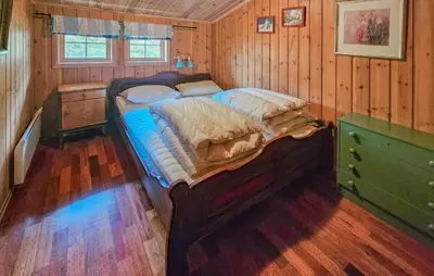 a bedroom with a large bed in a wooden room at 4 Bedroom Gorgeous Home In Rjukan in Rjukan