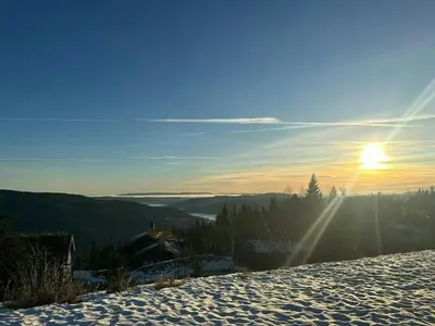 a snow covered hill with the sun in the sky at Bo På Norefjell Rett Ved Alpint Og Langrenn in Noresund