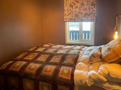 a bedroom with a bed with a quilt and a window at Panoramic Apartment In The Heart Of Beitostølen in Beitostøl