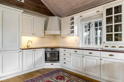 a kitchen with white cabinets and a wooden ceiling at Fjellkos, mountain cabin in Gol in Gol