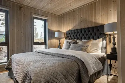a bedroom with a large bed and wooden walls at Trysilfjell hytteområde 2115 by Vacation Trysil in Trysil