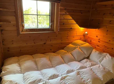 a large white bed in a room with a window at Cozy family cabin at Hovden in Bykle