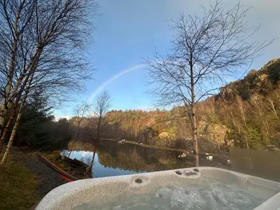 a bath tub with a view of a river at Aurora Bliss - Waterfront Jacuzzi & Sauna near Bergen in Askøy