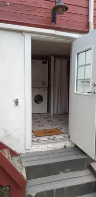 a front door of a house with a washing machine at Cozy bedroom & basement with amenities in Odda