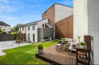 a backyard with a wooden deck with a couch at Trondheim's smallest detached house in the middle of the city centre! in Trondheim