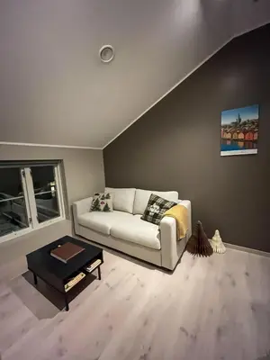 a living room with a white couch and a table at Trondheim's smallest detached house in the middle of the city centre! in Trondheim