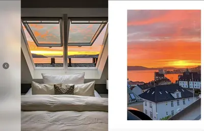 a bedroom with a window with a sunset at Bergenhus apartment in historical Sandviken in Bergen