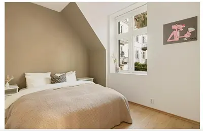 a bedroom with a bed and a window at Bergenhus apartment in historical Sandviken in Bergen