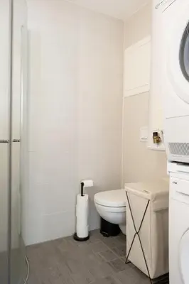 a white bathroom with a toilet and a sink at Central apartement in Kristiansund in Kristiansund