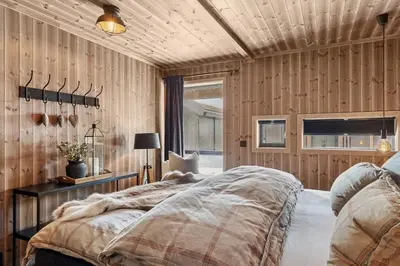 a bedroom with wood paneled walls and a bed at Large family cabin at Hafjell with ski in-ski out in Hafjell