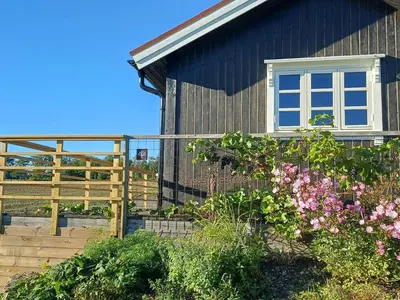 a house with a fence and flowers in front of it at Lovely tiny house with a dream view !