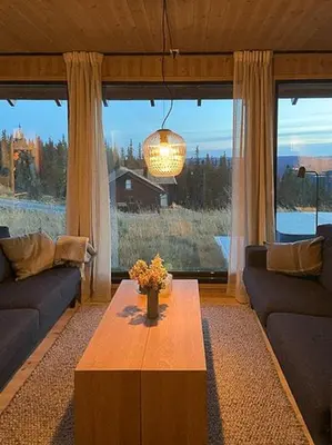 a living room with a table and a large window at Mountain Cabinin Valdres in Aurdal