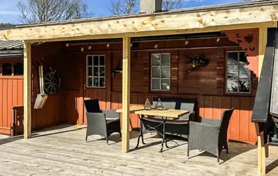 a wooden deck with a table and chairs on a cabin at Cabin With Terrace And Mountain Views In Tuddal in Tuddal