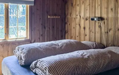 a room with two pillows on a couch with a window at Cabin With Terrace And Mountain Views In Tuddal in Tuddal