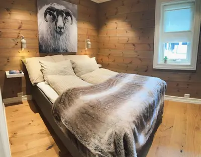 a large bed in a room with a picture of a cow at Sentral leilighetshytte 16A in Stranda