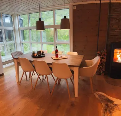 a dining room with a wooden table and chairs at Sentral leilighetshytte 16A in Stranda