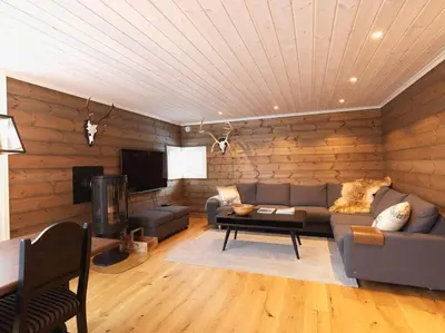 a living room with a couch and a tv at Stranda Fjellgrend 3 bedrooms - 12A in Stranda