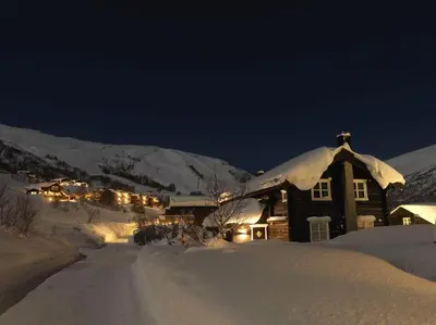 a house is covered in snow at night at Stranda Fjellgrend 3 bedrooms - 12A in Stranda
