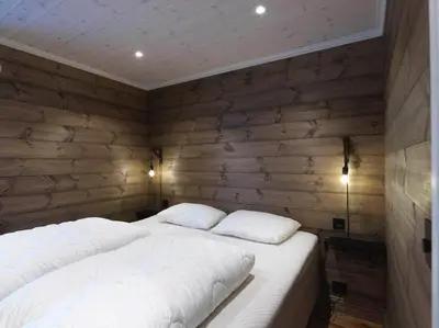 a bed with two pillows in a room with wooden walls at Stranda Fjellgrend 3 bedrooms - 12A in Stranda