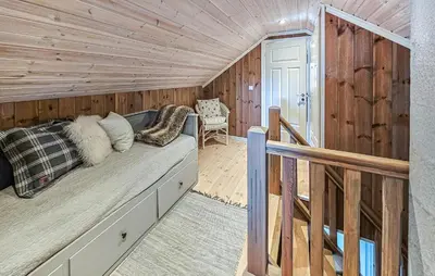 a bed in a room with a wooden wall at Nice Home In Rauland With Wifi in Rauland