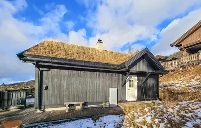 a building with a grass roof with a bench at Nice Home In Rauland With Wifi in Rauland